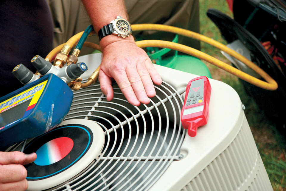 Close-up of man performing a maintenance test on a heat pump unit